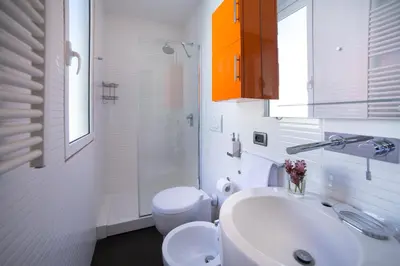 a white bathroom with a sink and a toilet at Rent in Rome - IV Novembre in Rome