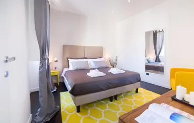 a bedroom with a bed and a desk and a table at Rent in Rome - IV Novembre in Rome