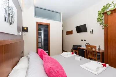 a room with a bed with pink pillows on it at Filomena Arthouse in Rome