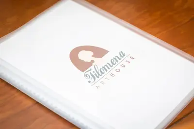 a white paper with a logo on top of a table at Filomena Arthouse in Rome