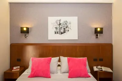 a bedroom with a bed with two pink pillows at Filomena Arthouse in Rome