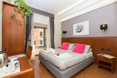 a bedroom with a large bed with pink pillows at Filomena Arthouse in Rome