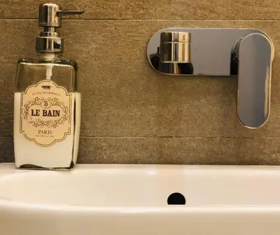 a bottle of soap sitting on top of a sink at Belsiana Luxury Apartment in Rome