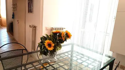 a vase of sunflowers sitting on a glass table at Lovely 5 min walk to Saint Peter Basilica in Rome