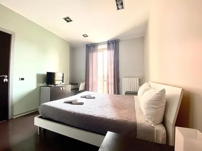 a bedroom with a bed with a chair and a window at Gemini Guest House in Rome