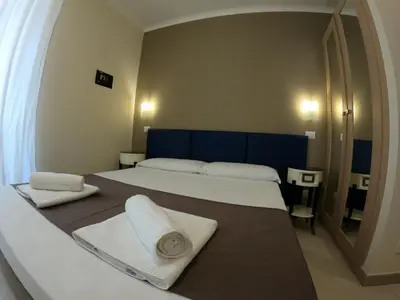 a bedroom with two beds with towels and a mirror at Relais central Turati in Rome