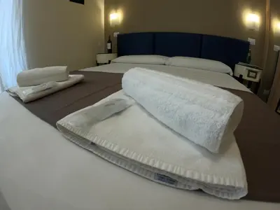 two beds with white towels on top of them at Relais central Turati in Rome