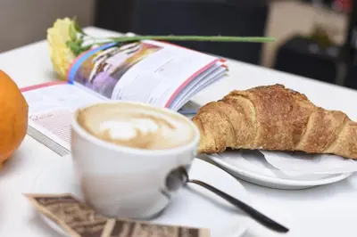 a cup of coffee and a piece of bread on a table at Relais central Turati in Rome