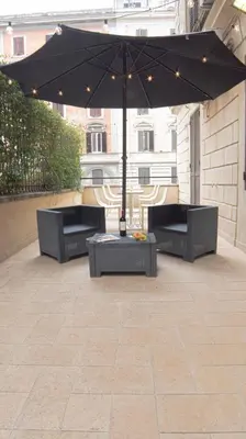 a patio with two benches and an umbrella at Relais central Turati in Rome