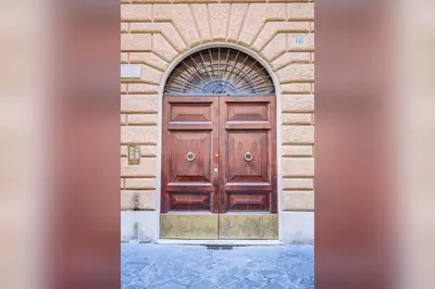 a large wooden door in a stone building at GuestHost - Spanish Steps Luxury Apartment in Rome