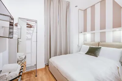 a bedroom with a large white bed and a mirror at GuestHost - Spanish Steps Luxury Apartment in Rome