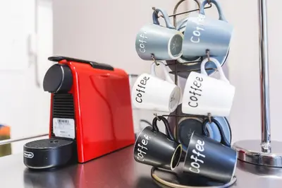 a rack of coffee cups and a red suitcase at GuestHost - Spanish Steps Luxury Apartment in Rome