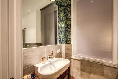 a bathroom with a sink and a mirror at Lovely Rome Apartments - Historic City center in Rome