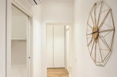 a hallway with white walls and a mirror at Lovely Rome Apartments - Historic City center in Rome