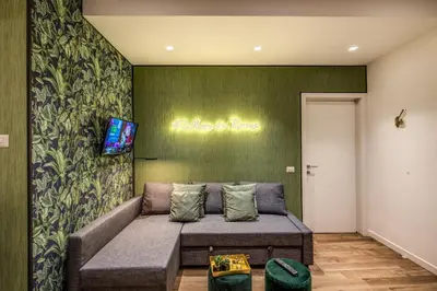 a living room with a couch and a tv on a wall at Lovely Rome Apartments - Historic City center in Rome