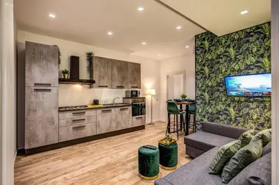 a living room with a couch and a kitchen at Lovely Rome Apartments - Historic City center in Rome