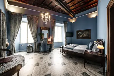 a bedroom with blue walls and a bed and a chandelier at Navona Grand Suite in Rome
