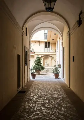 an alley with an archway in a building with potted plants at Navona Grand Suite in Rome