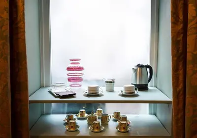 a shelf with cups and tea pots in a room at Navona Grand Suite in Rome