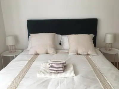 a white bed with a black headboard and two tables at La Terrazza di Isabel in Rome