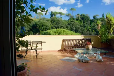 a patio with a bench and a table and chairs at La Terrazza di Isabel in Rome