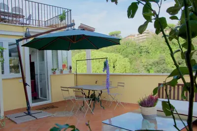 a patio with a table and an umbrella on a balcony at La Terrazza di Isabel in Rome