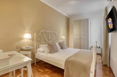 a bedroom with a bed and a desk and a tv at ATRHOME penthouse Frattina in Rome