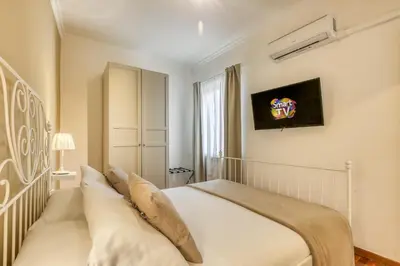 a bedroom with a white bed and a tv on the wall at ATRHOME penthouse Frattina in Rome