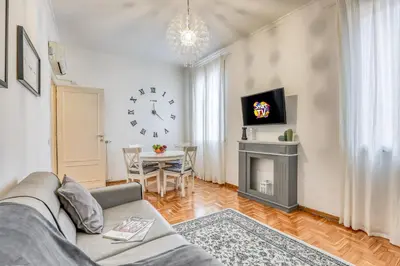 a living room with a couch and a clock on the wall at ATRHOME penthouse Frattina in Rome