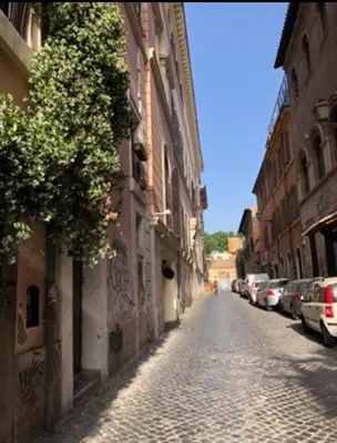 a street with cars parked on the side of a building at New studio a Trastevere in Rome