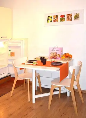 a kitchen with a table with chairs and a table with a bowl of fruit at New studio a Trastevere in Rome