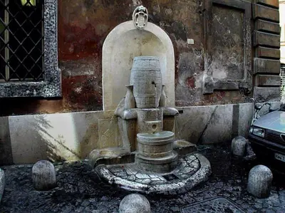 a stone fountain in front of a building at New studio a Trastevere in Rome