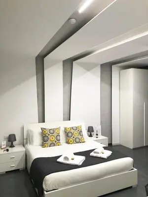 a bedroom with a large bed with yellow and black pillows at Le Vie del Vaticano in Rome