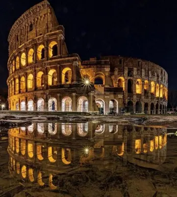 a building with its reflection in the water at night at Le Vie del Vaticano in Rome