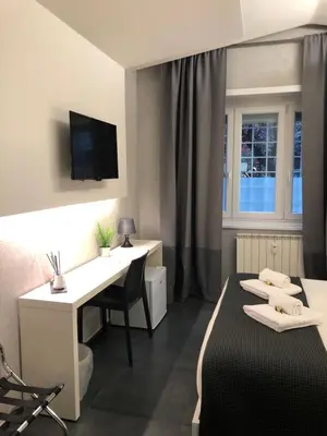 a hotel room with a bed and a desk and a window at Le Vie del Vaticano in Rome