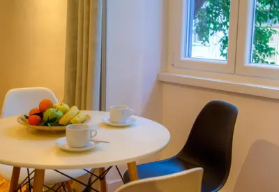 a table with a bowl of fruit and two cups at App Beccaria Apartments in Rome in Rome