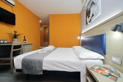 a hotel room with a large bed and a table at Porta Pia Comfy Rooms in Rome
