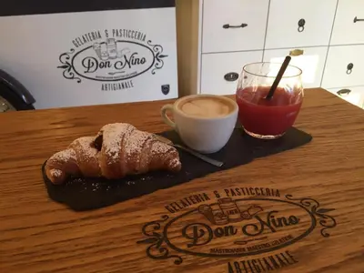 a table with a plate of food and a cup of coffee at Porta Pia Comfy Rooms in Rome