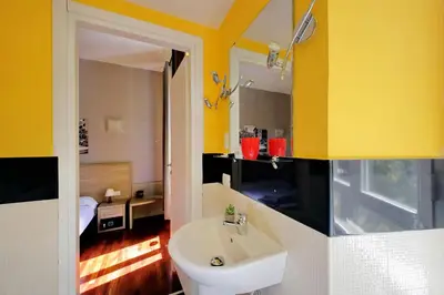 a bathroom with a white sink and yellow walls at Porta Pia Comfy Rooms in Rome
