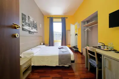 a hotel room with a bed and a desk at Porta Pia Comfy Rooms in Rome