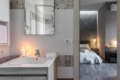 a bathroom with a sink and a bed in a room at City Break Nomentana in Rome