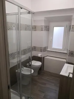a bathroom with a toilet and a glass shower at City Break Nomentana in Rome
