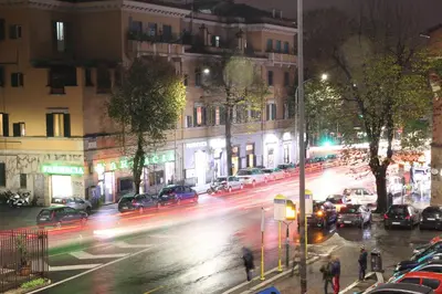 a busy city street at night with cars at City Break Nomentana in Rome
