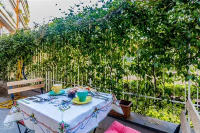 a table with two cups on it next to a bush at Garden Rooms by Casa Proto in Rome