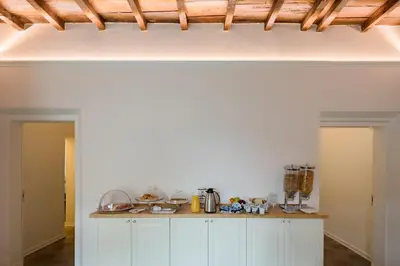 a kitchen with white cabinets and a wooden ceiling at Palazzo Lupardi Relais in Rome