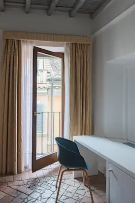 a desk and a chair in a room with a window at Palazzo Lupardi Relais in Rome