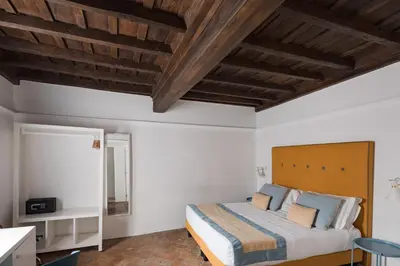 a bedroom with a bed and a wooden ceiling at Palazzo Lupardi Relais in Rome