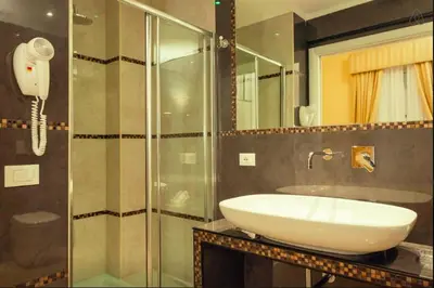 a bathroom with a sink and a glass shower at VIA VENETO SUITE 107 in Rome