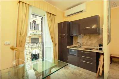 a kitchen with a glass counter top and a window at VIA VENETO SUITE 107 in Rome