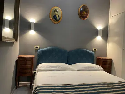 a bedroom with a bed and two pictures on the wall at VIA VENETO SUITE 104 in Rome